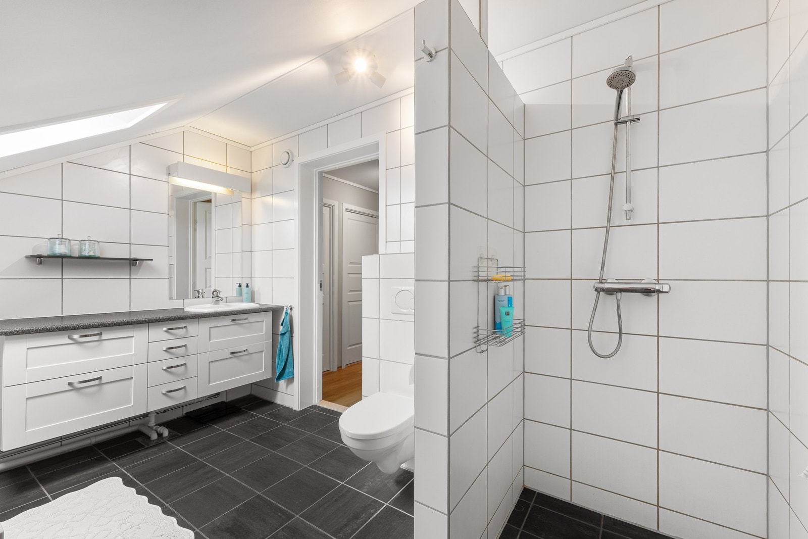 Flislagte overflater og en gjennomtenkt romløsning gir badet et tidløst uttrykk. Galleribilde