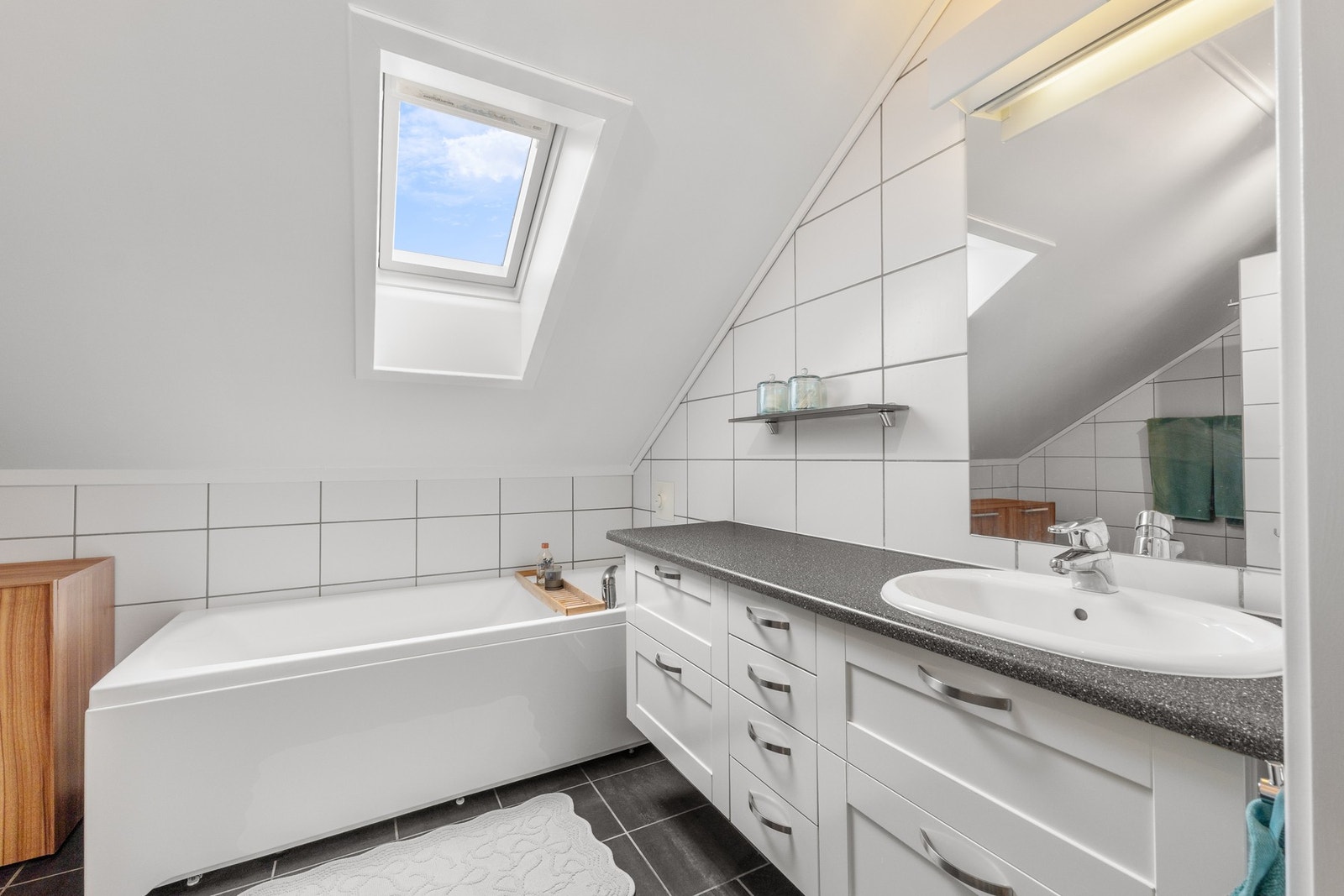 Badet er innredet med praktisk baderomsinnredning som gir rikelig med skap- og skuffeplass. Galleribilde