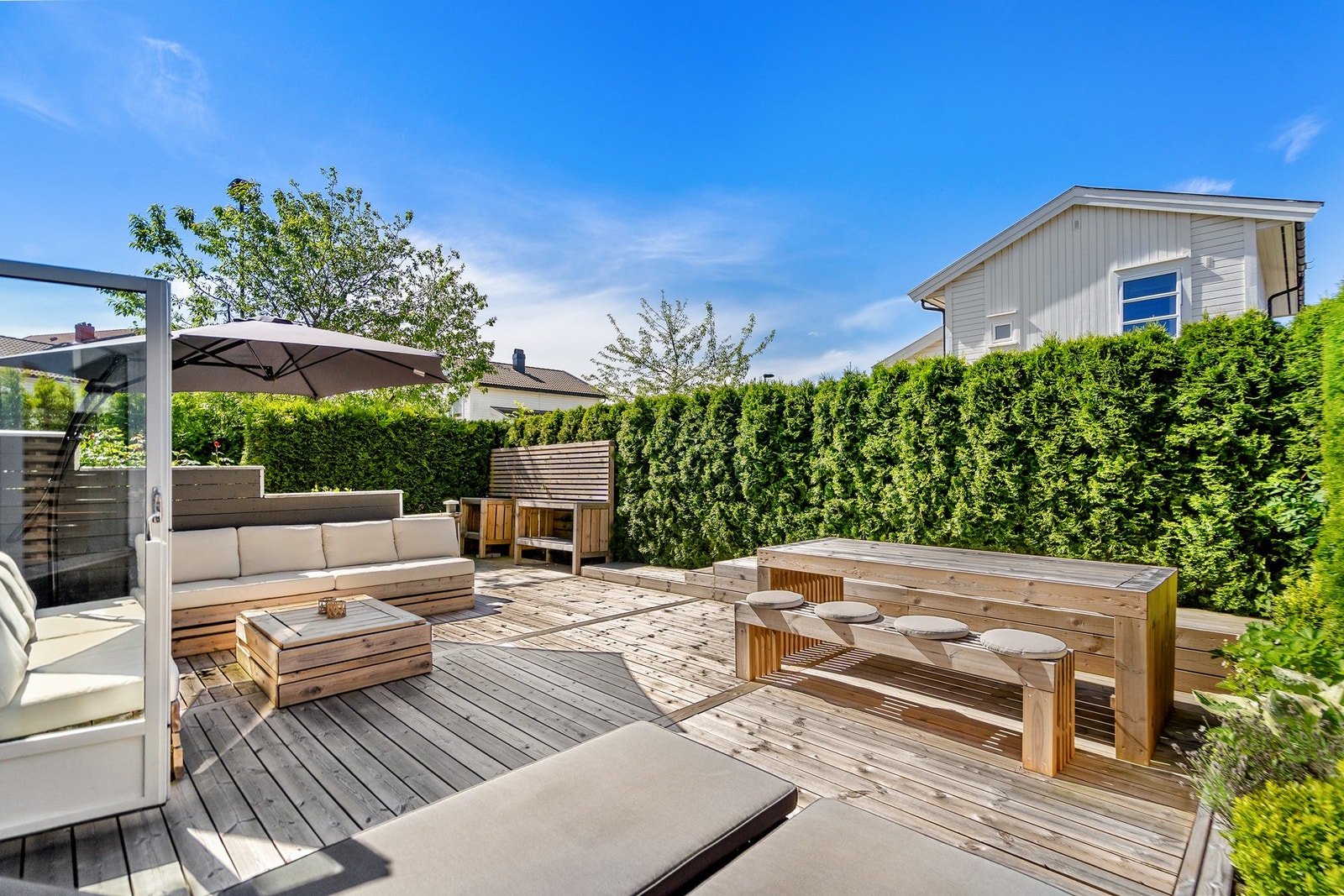 Skjermet og solrik terrasse med god plass til både spisegruppe og loungeområde. Her kan du nyte lange sommerdager i private omgivelser, omkranset av tett hekk som gir minimalt innsyn. Galleribilde