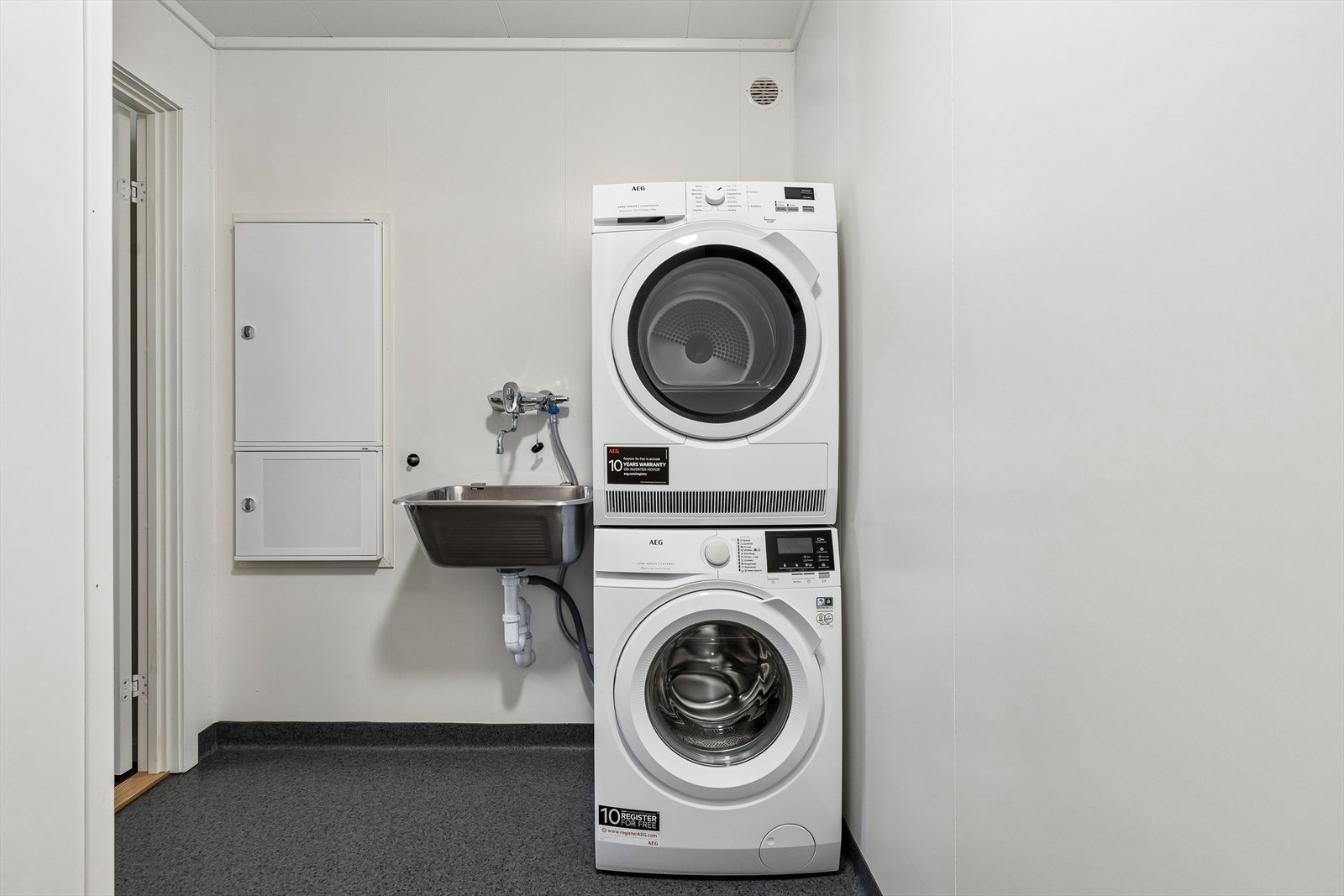 Separat vaskerom med gulvvarme, opplegg for vaskemaskin og vegghengt oppvaskkum. Galleribilde