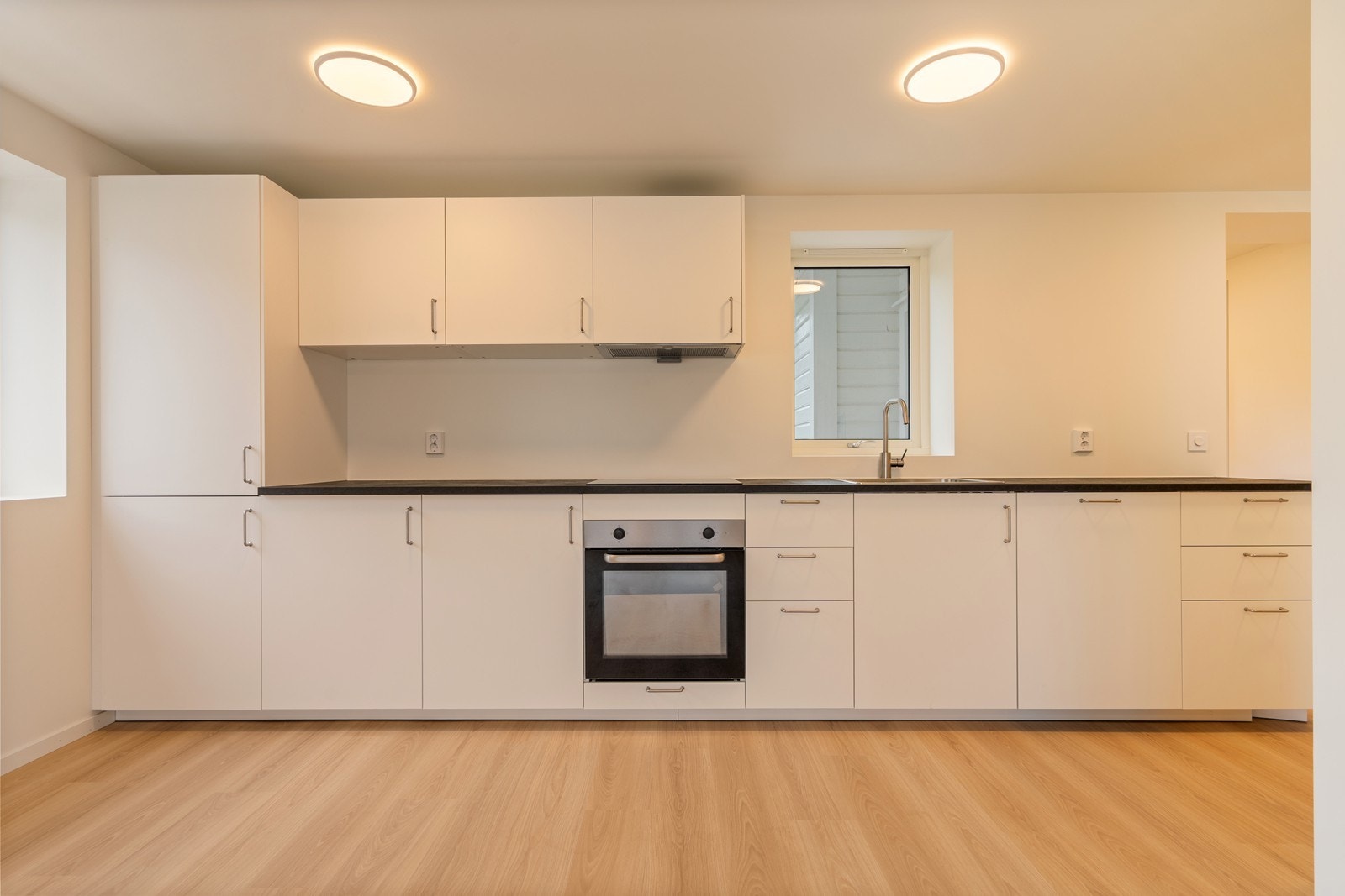 Tidsriktig kjøkkeninnredning fra IKEA i hvit utførelse. Benkeplate i laminat. Integrert kjøl/fryseskap, stekeovn, platetopp og oppvaskmaskin. Komfyrvakt og lekkasjedetektor. Kjøkkenventilator med avtrekk ut. Galleribilde