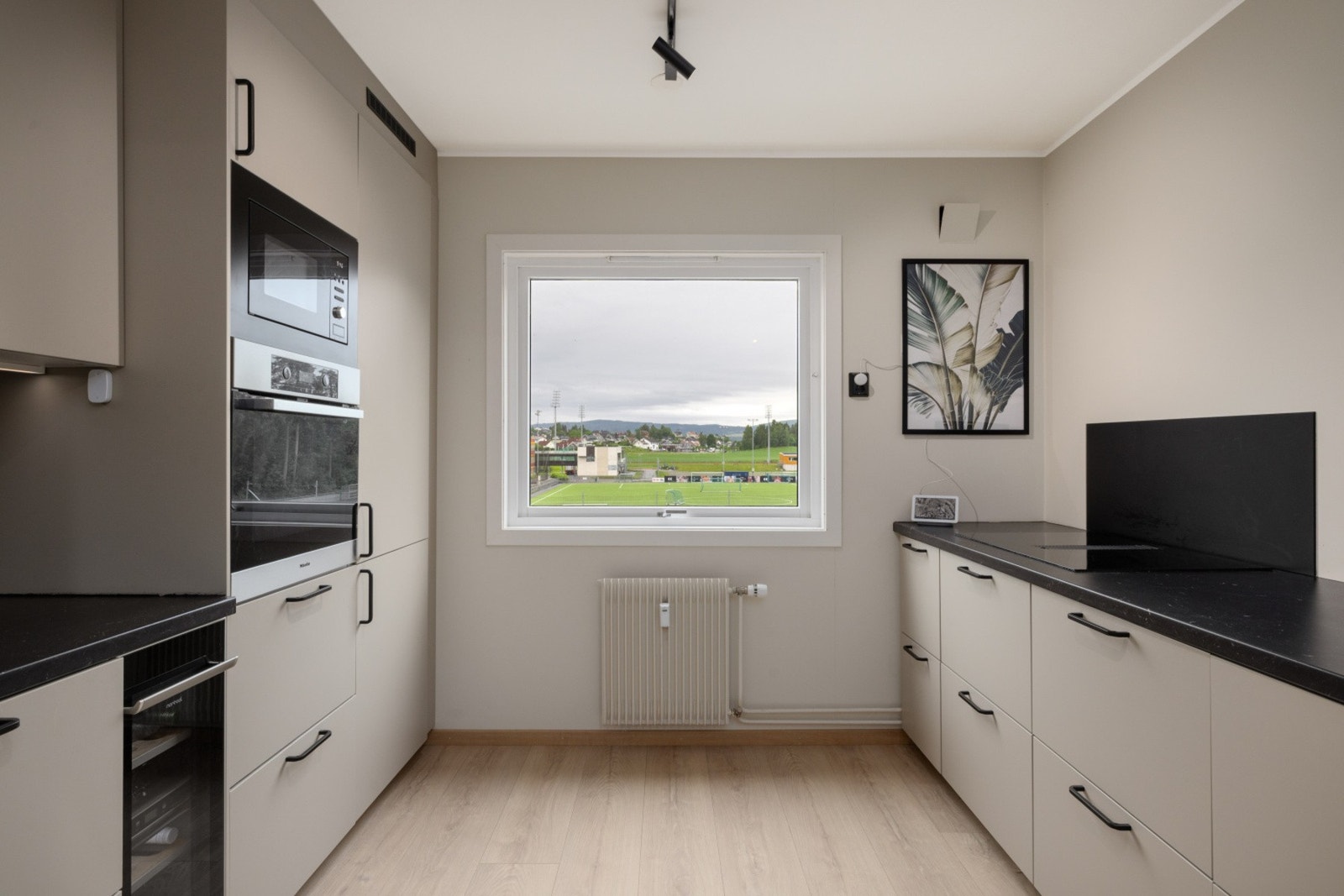 Kjøkkenet kombinerer funksjonalitet og moderne design med gode arbeidsflater og rikelig oppbevaringsplass. Galleribilde