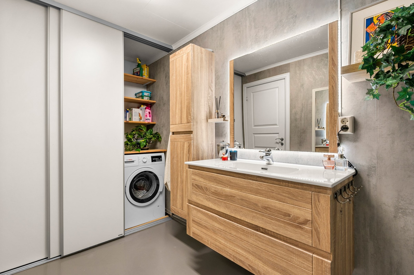 Videre har badet praktisk skyvedørsgarderobe som skjuler løsning for oppvaskmaskinen. Galleribilde