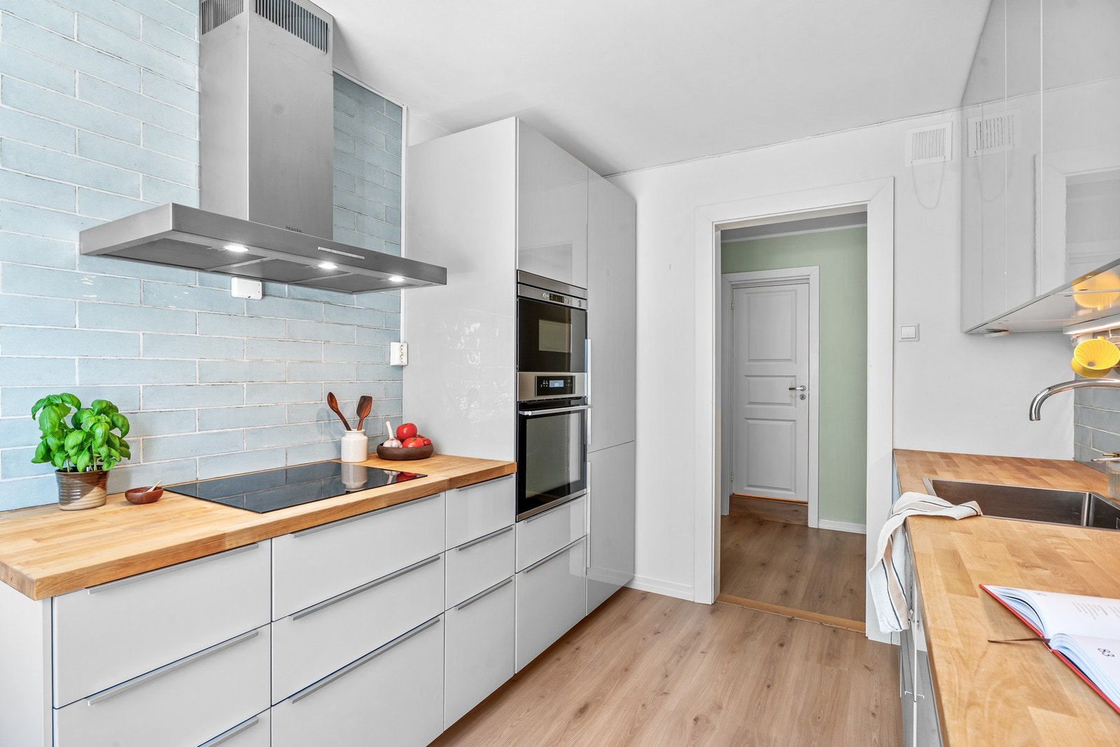 Innredningen er stilren fra IKEA, med slette høyglansfronter og integrerte hvitevarer fra 2021. Høiax varmtvannsbereder på 107 liter plassert i benkeskap. Galleribilde