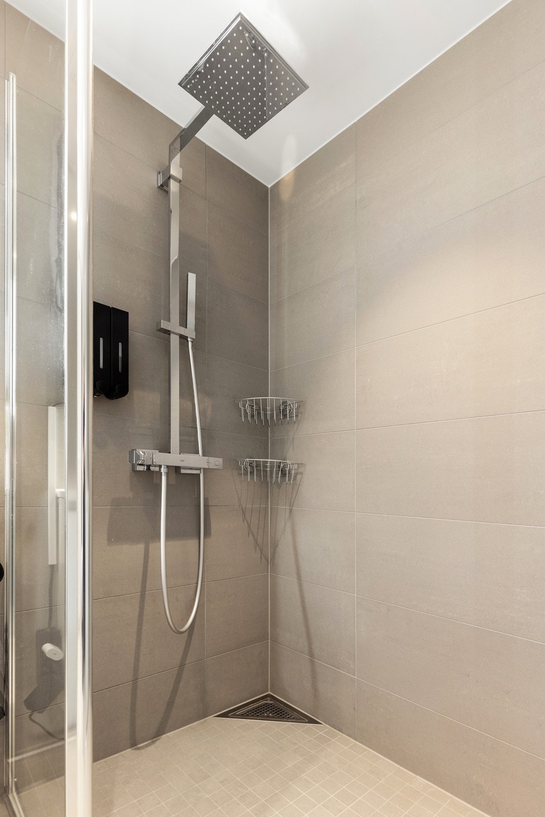 Dusjnisje med nedsenket sone, mosaikkfliser og dusjarmatur fra Grohe med både håndholdt og regnfallsdusj. Galleribilde