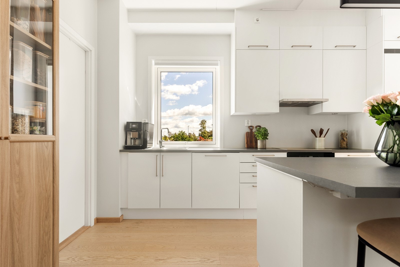 Kjøkkeninnredning fra Sigdal med hvite, glatte fronter og laminatbenkeplate. Galleribilde