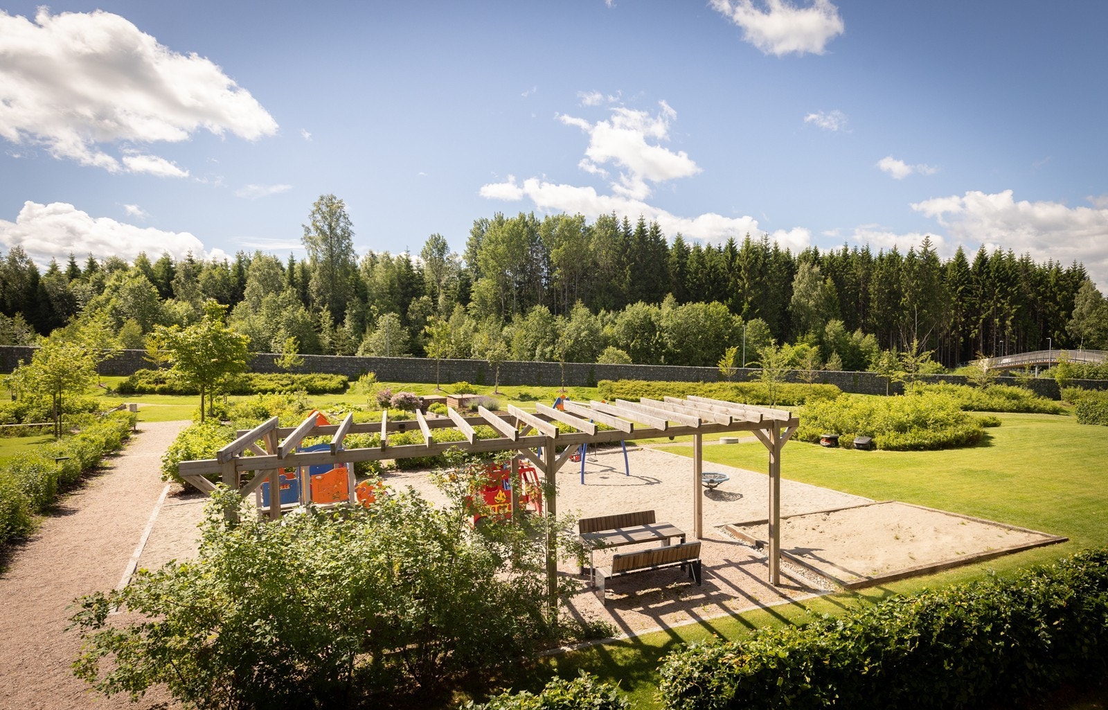Utsikt mot lekeplass og pergola fra balkongen. Galleribilde