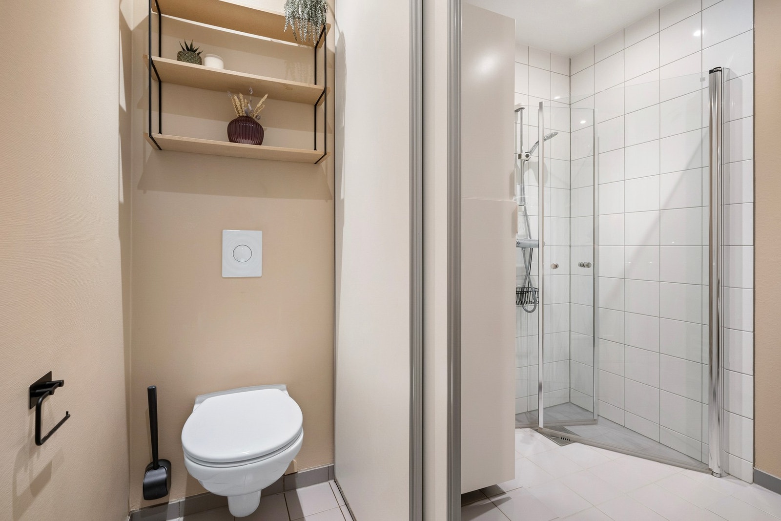 Badet i første etasje fungerer samtidig som vaskerom og er innredet med doble servanter, vegghengt toalett, dusjhjørne med glassvegger og opplegg for vaskemaskin. Galleribilde
