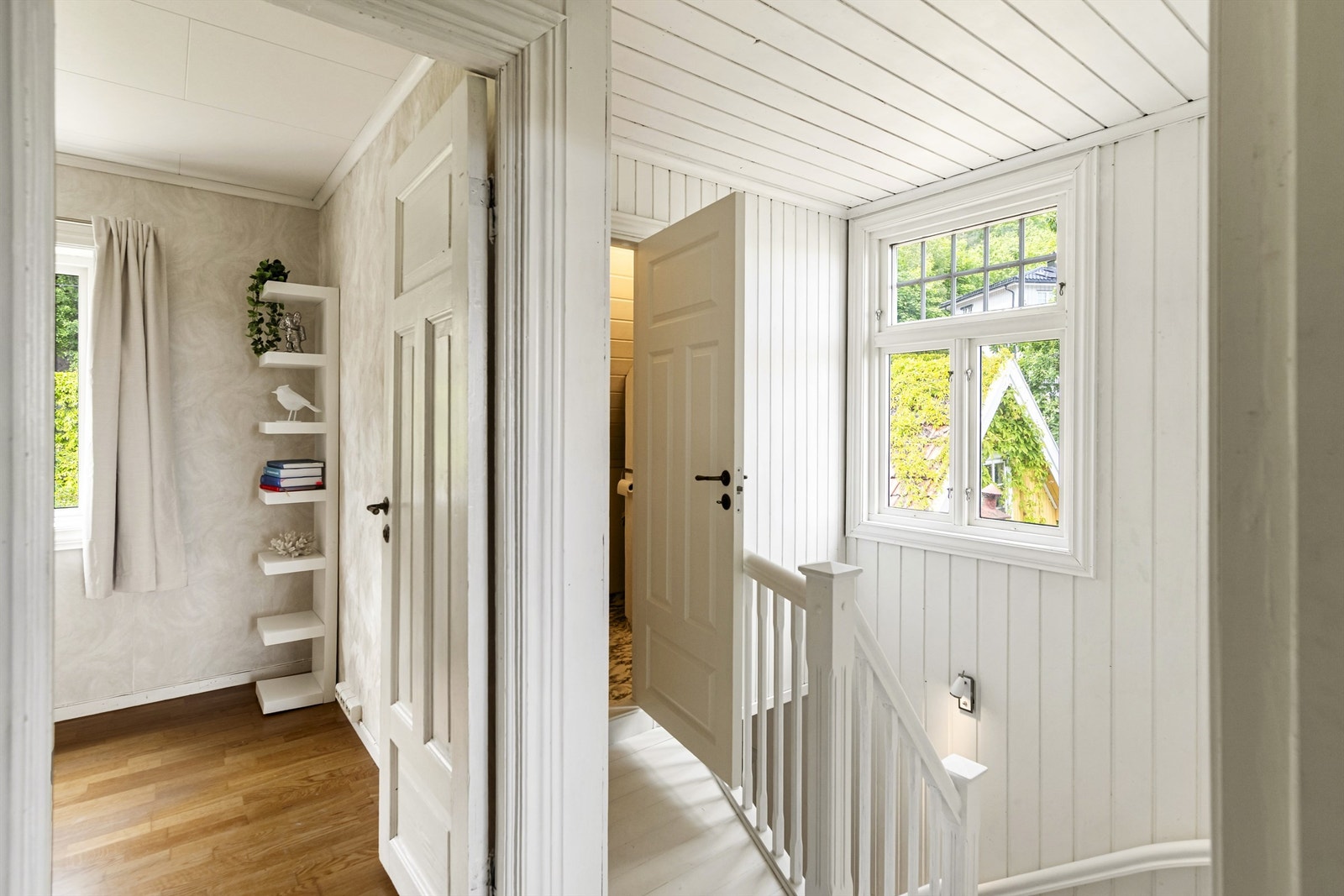 Tretrapp med rekkverk av stående trespiler leder opp til andre etasje. Galleribilde
