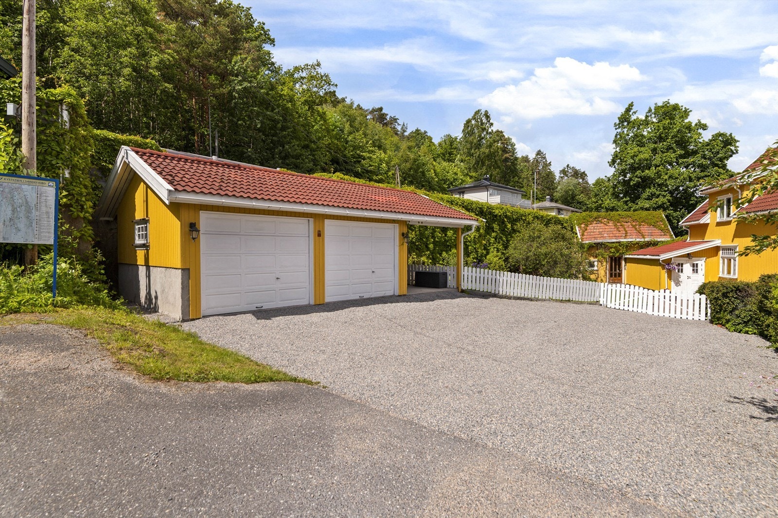 Dobbelgarasje på 29 m² oppført i 2002. Én port har elektrisk åpner. Til venstre for garasjen har du sti opp til Hystadveien, hvor det er busstopp. Galleribilde