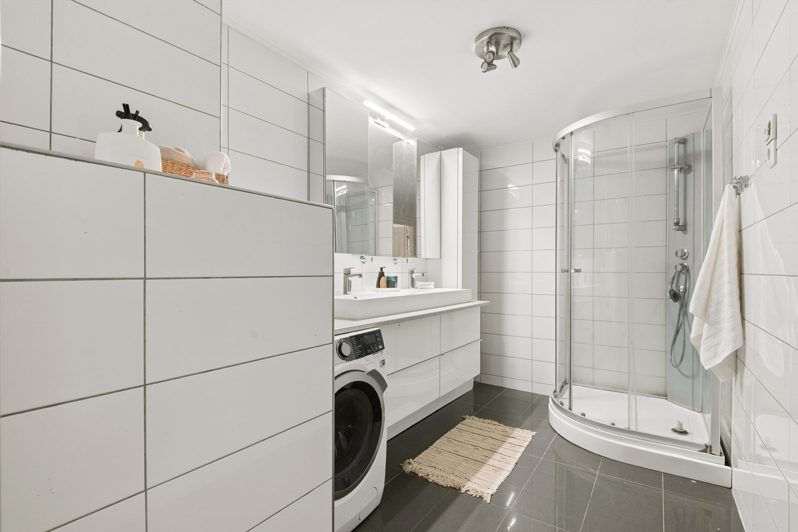 Badet er utstyrt med dusjkabinett, to servanter og opplegg for vaskemaskin Galleribilde