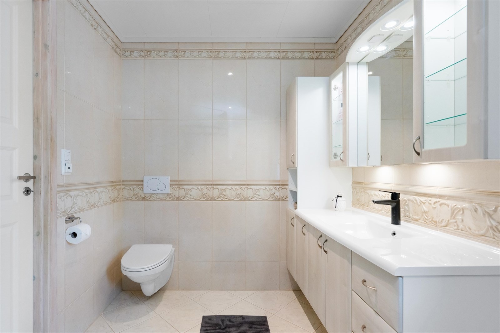 Badet er utstyrt med vegghengt toalett, dusj og en servantinnredning med god oppbevaringsplass. Galleribilde