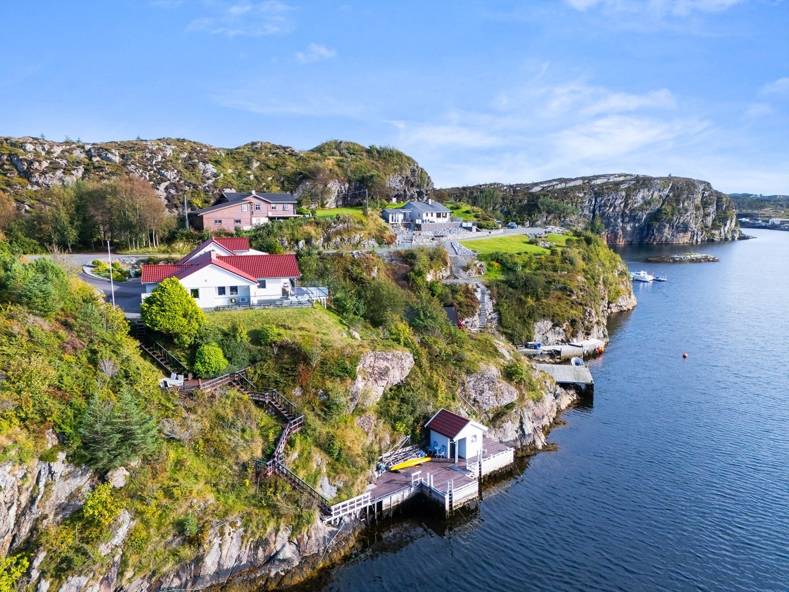 En oversikt som viser boligens plassering i terrenget, med naustet ved sjøkanten. Galleribilde