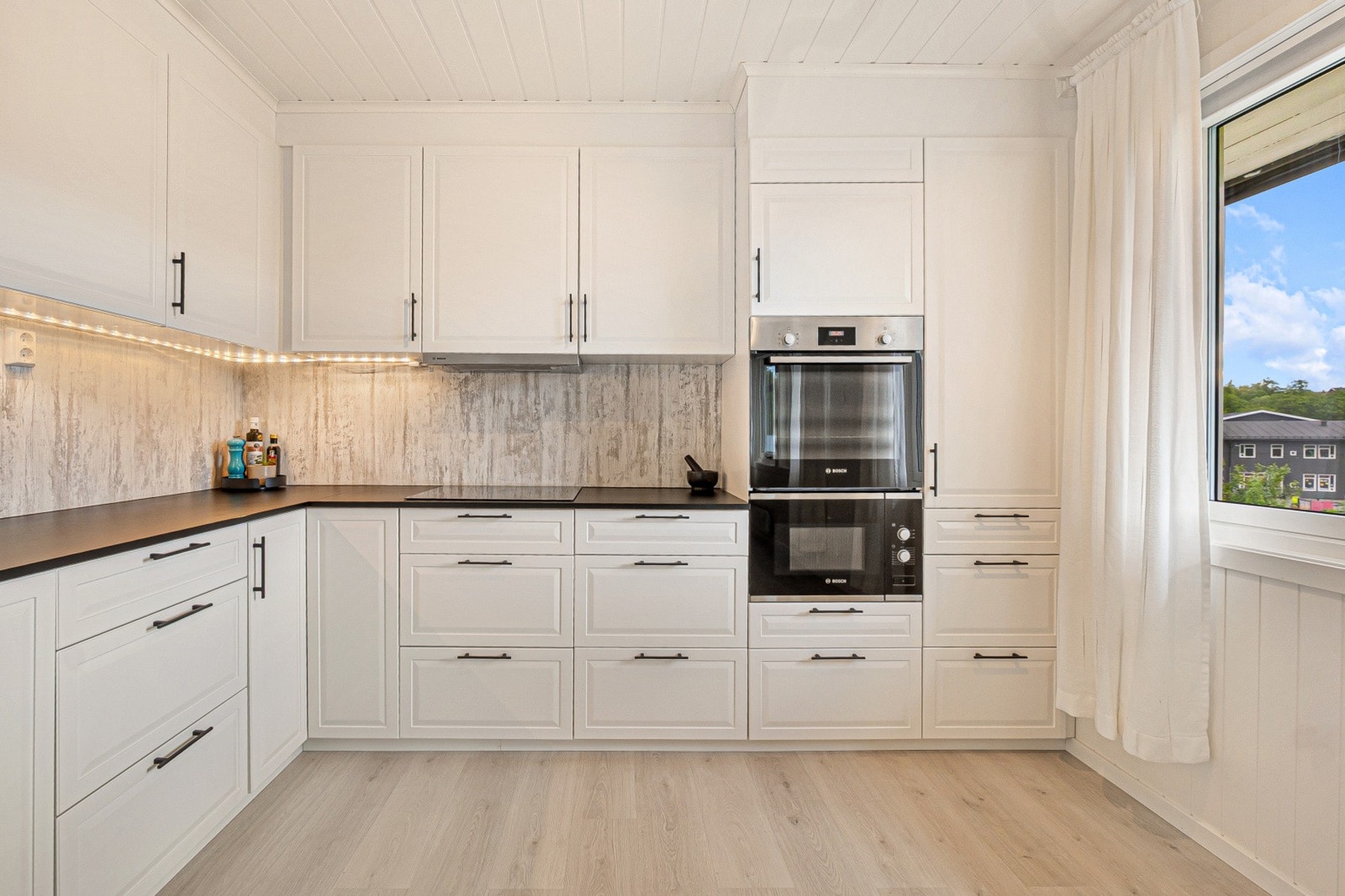 Kitchenboard er montert under overskapene for enkel rengjøring. Galleribilde