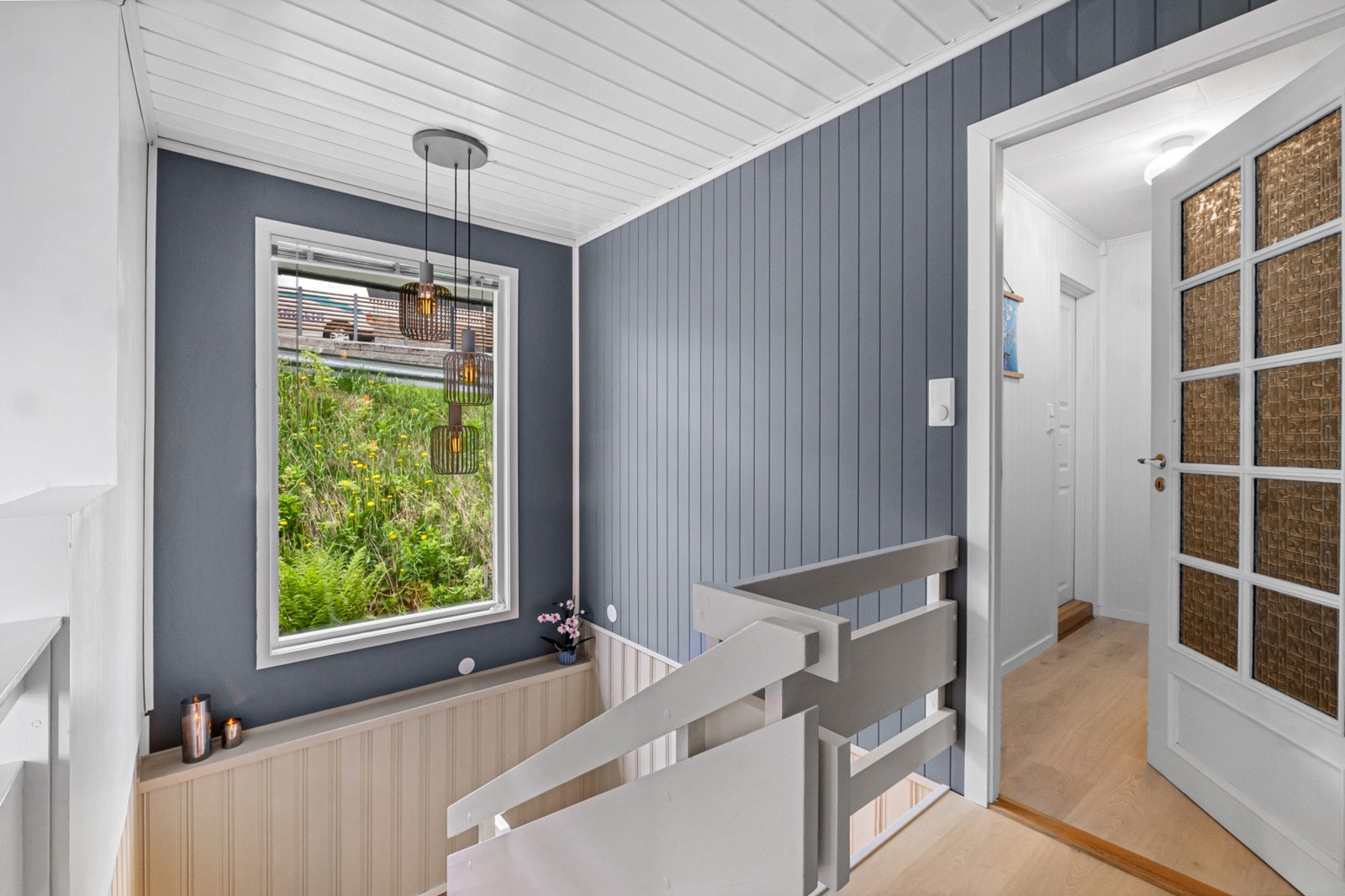 Den malte tretrappen har rekkverk som skiller mot stuen. Galleribilde