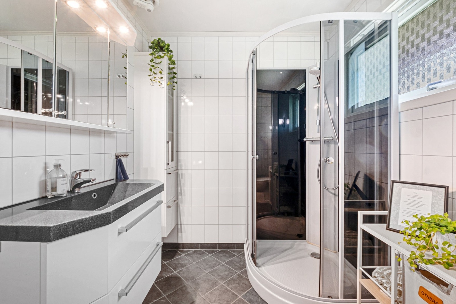 Badet er utstyrt med dusjkabinett, toalett og servant med innredning. Galleribilde