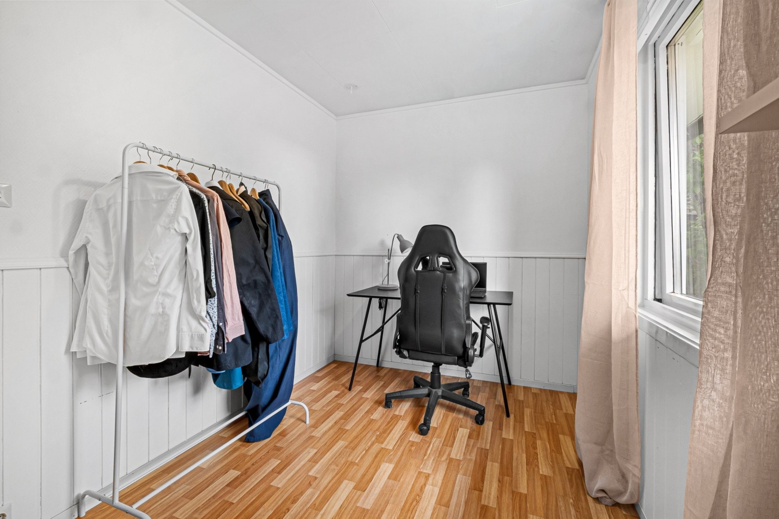 Rommet har malte panelvegger og laminat på gulvet. Galleribilde