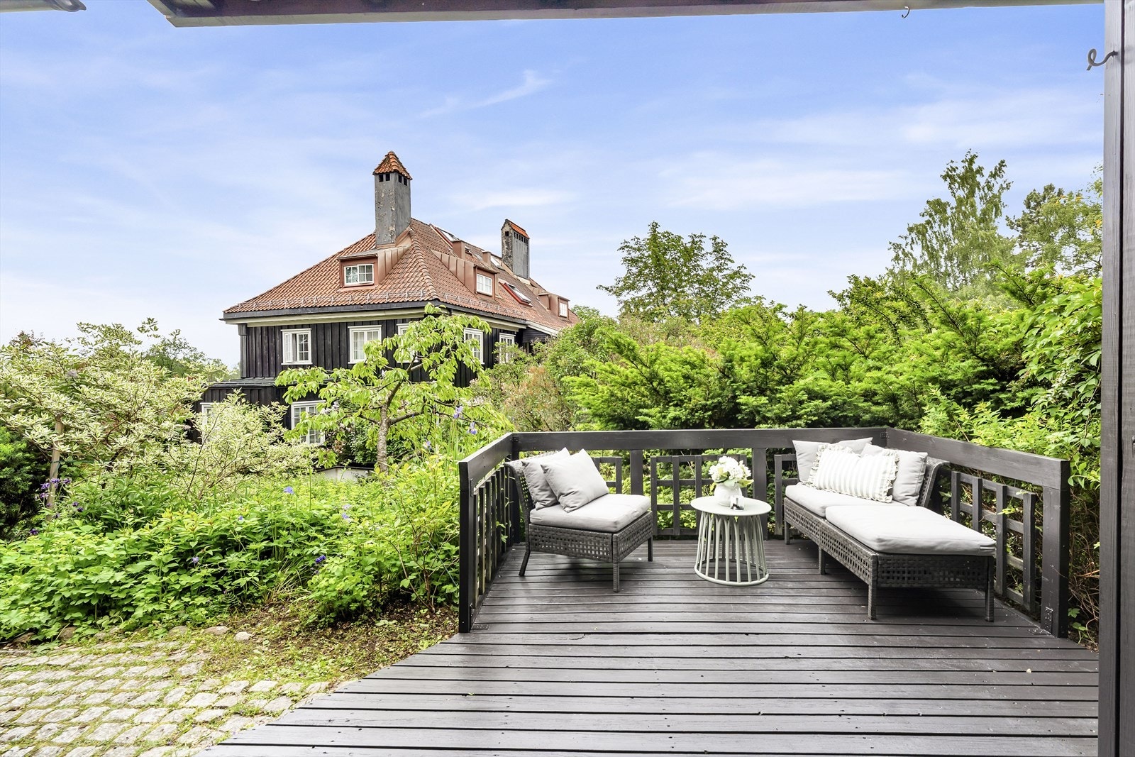 En lun terrasse som føles som en naturlig forlengelse av boligens innendørs oppholdsarealer. Galleribilde