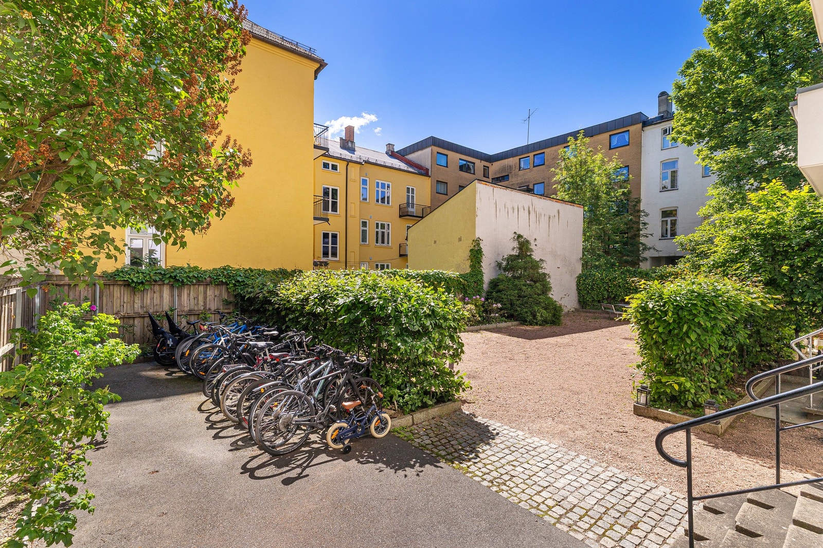 Hyggelig bakgård med beplantning, sykkelparkering og sittegruppe. Galleribilde