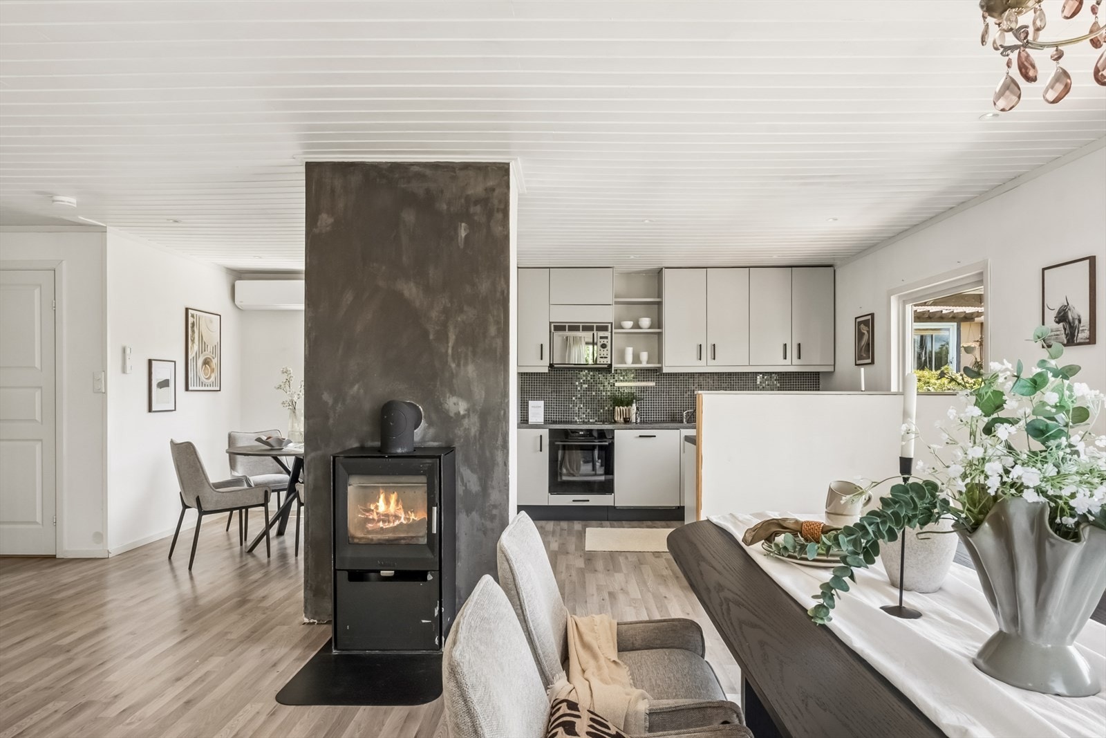 En peisovn gir varme og hygge i den åpne sonen mellom spisestue og kjøkken. Galleribilde