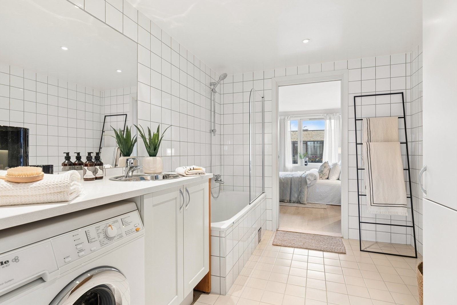 Fra soverommet har du direkte inngang til et stort, flislagt bad med badekar, vannbåren gulvvarme og opplegg for vaskemaskin. Galleribilde
