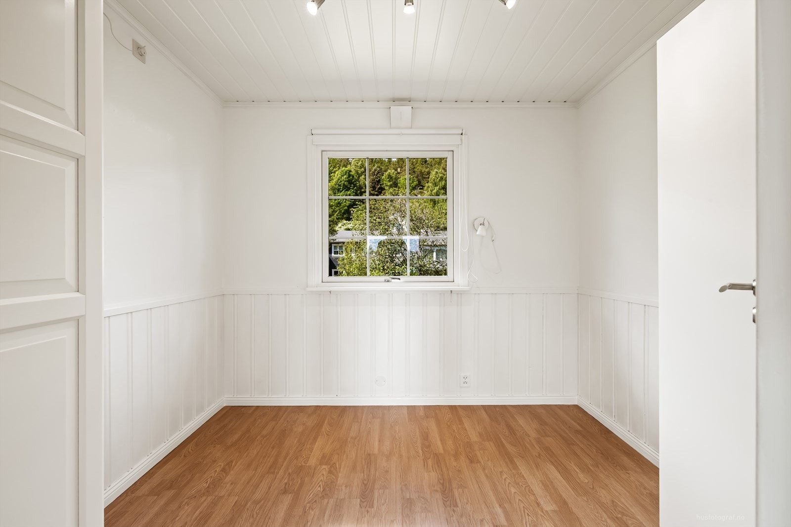Rommet har malte panelplater på veggene og laminat på gulvet. Galleribilde