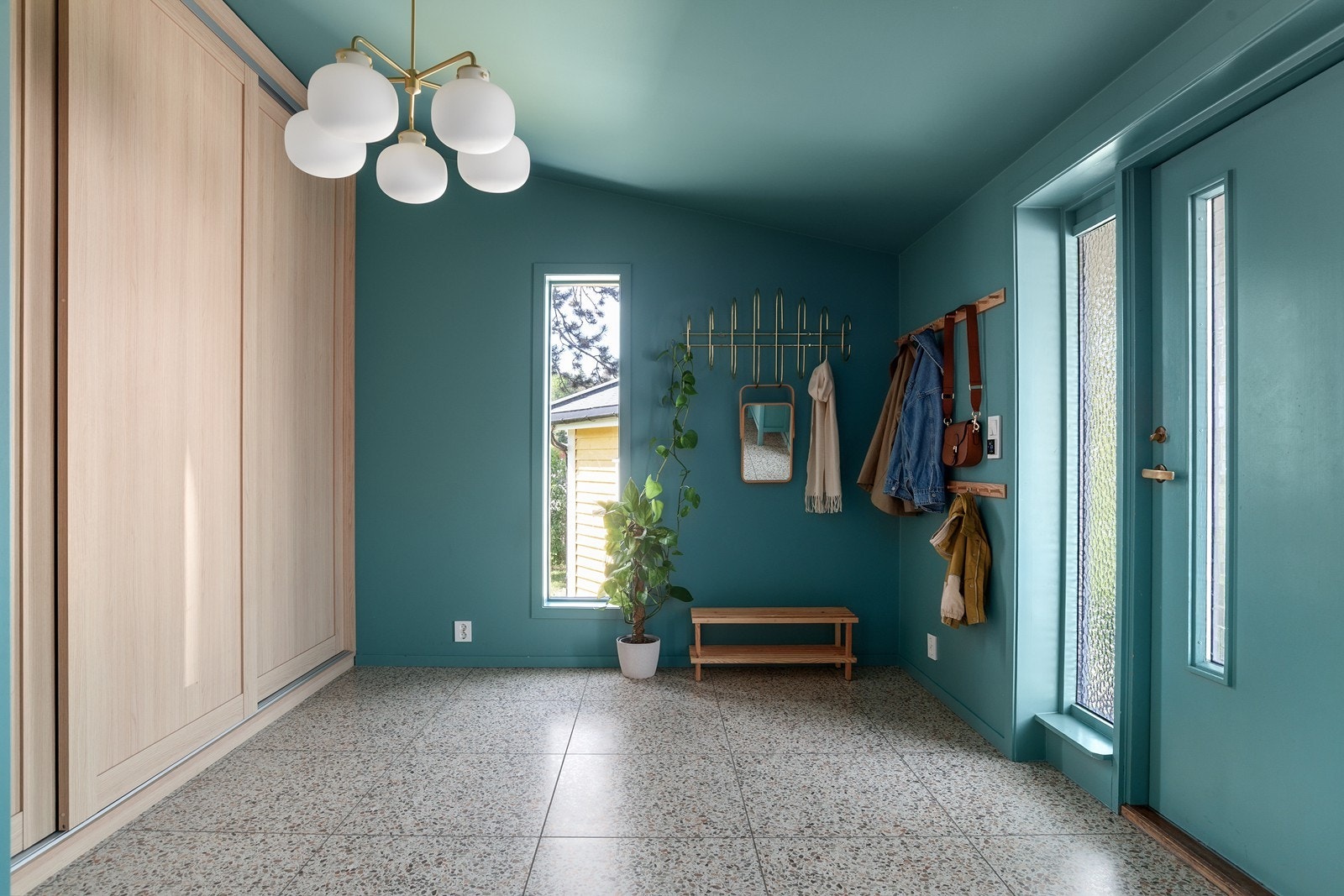 Romslig entré/hall med flislagt gulv, varmekabler og god oppbevaringsplass i stor skyvedørsgarderobe. Vegger og himling er malt i en fargerik tone som gir rommet særpreg. Galleribilde