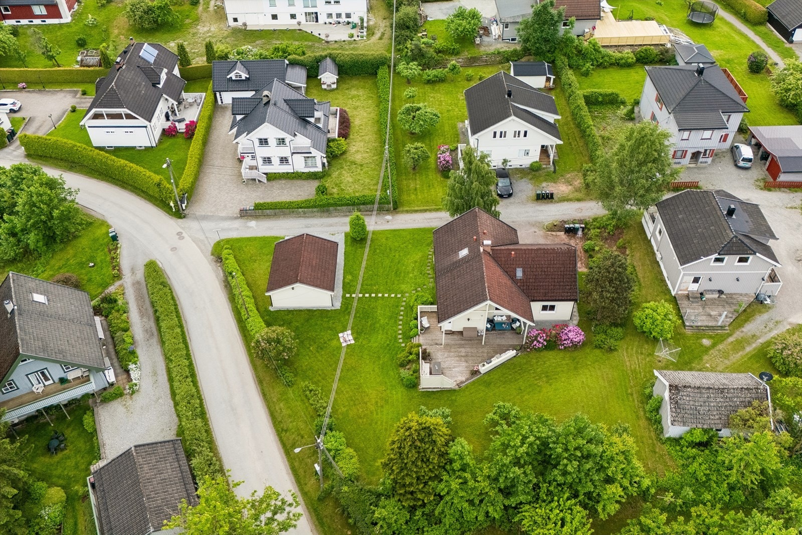 Oversikt over eiendommen som viser den store tomten, boligen og garasjen. Galleribilde
