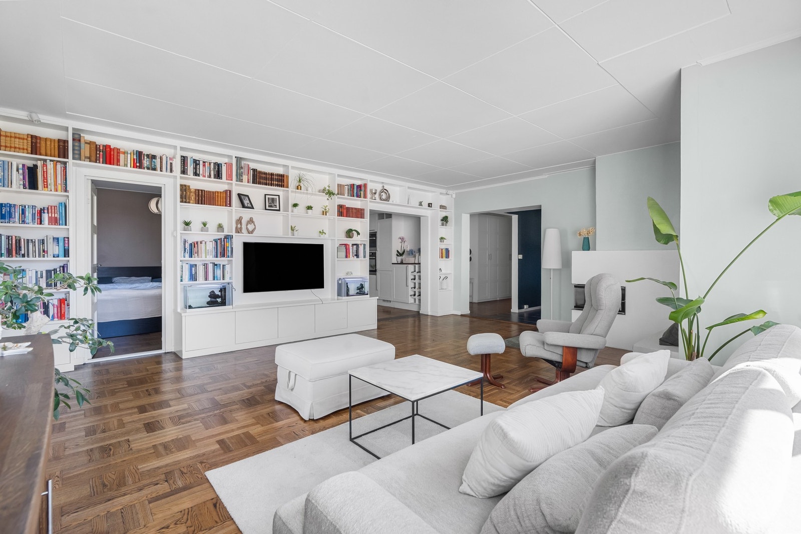 Stuen har plassbygget hylle på hele veggen mot kjøkken, og stor åpning mot gang / spisetue og mot kjøkkenet. Galleribilde