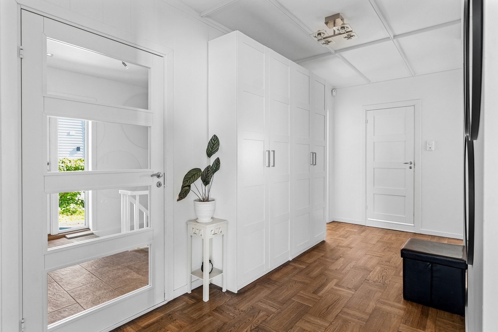 Det er fine glassfelter i ytterdør og glassfelt på siden av ytterdøren, samt glassdør som leder inn til mellomgangen. Mellomgangen har god garderobeplass og kott. Galleribilde