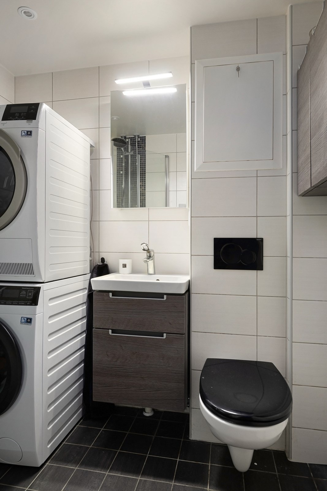 Badet har veggmontert klosett og opplegg for vaskemaskin og tørketrommel. Galleribilde