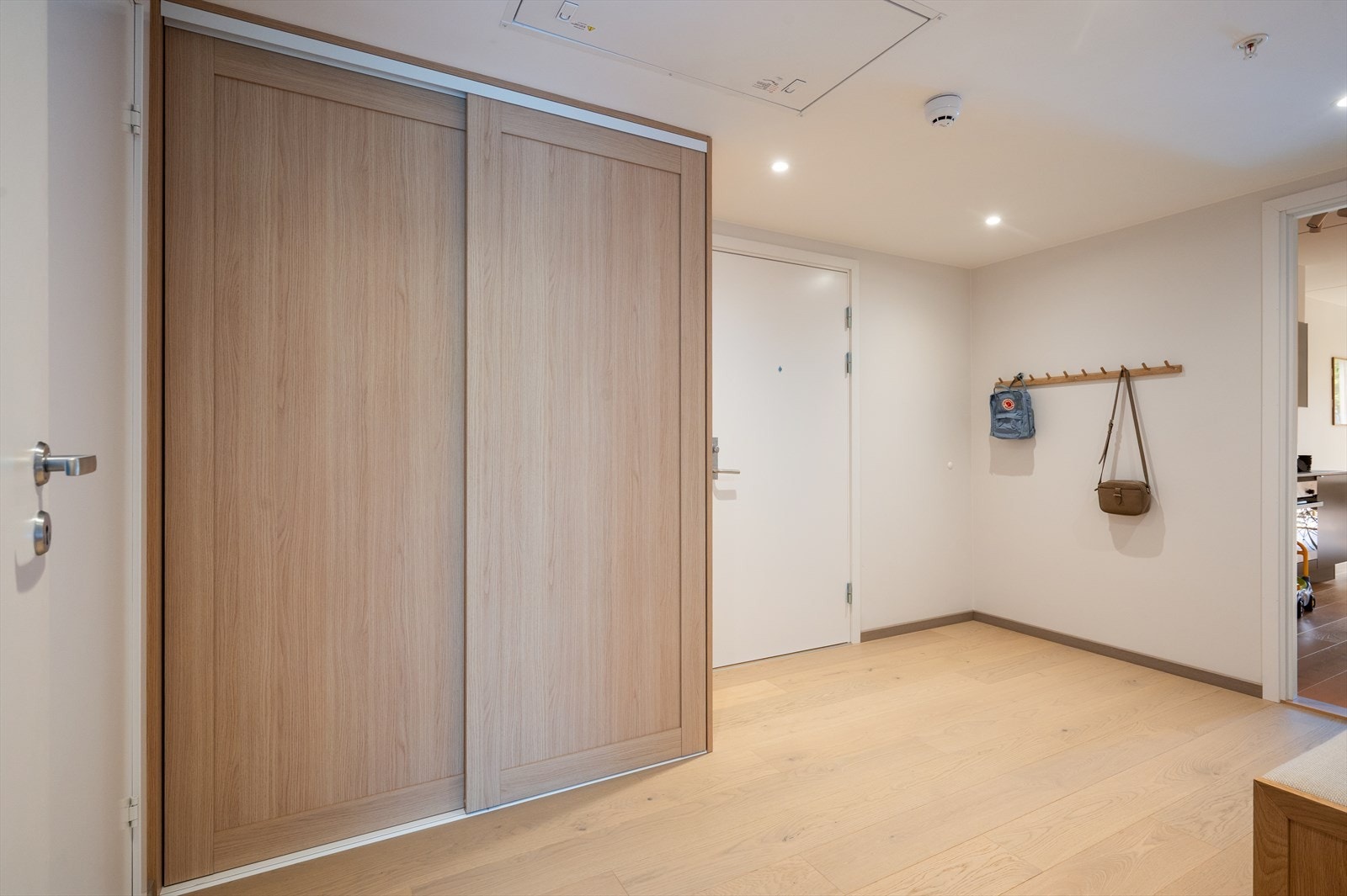 Koselig og innbydende inngangsparti med en praktisk, romslig skyvedørsgarderobe som gir rikelig med oppbevaringsplass for yttertøy, sko og annet tilbehør. Galleribilde