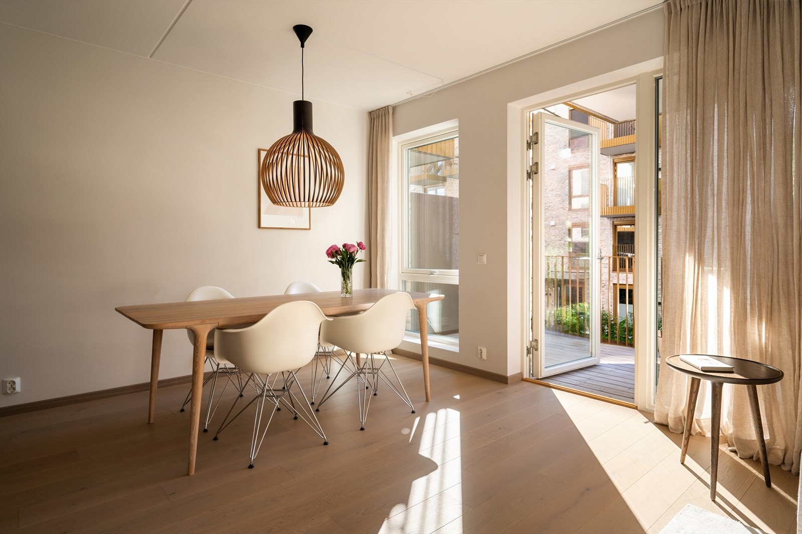 Store vindusflater fra gulv til tak slipper inn rikelig med dagslys og gir stuen et lyst og luftig preg, samtidig som de byr på et hyggelig utsyn mot sameiets fellesområder. Galleribilde