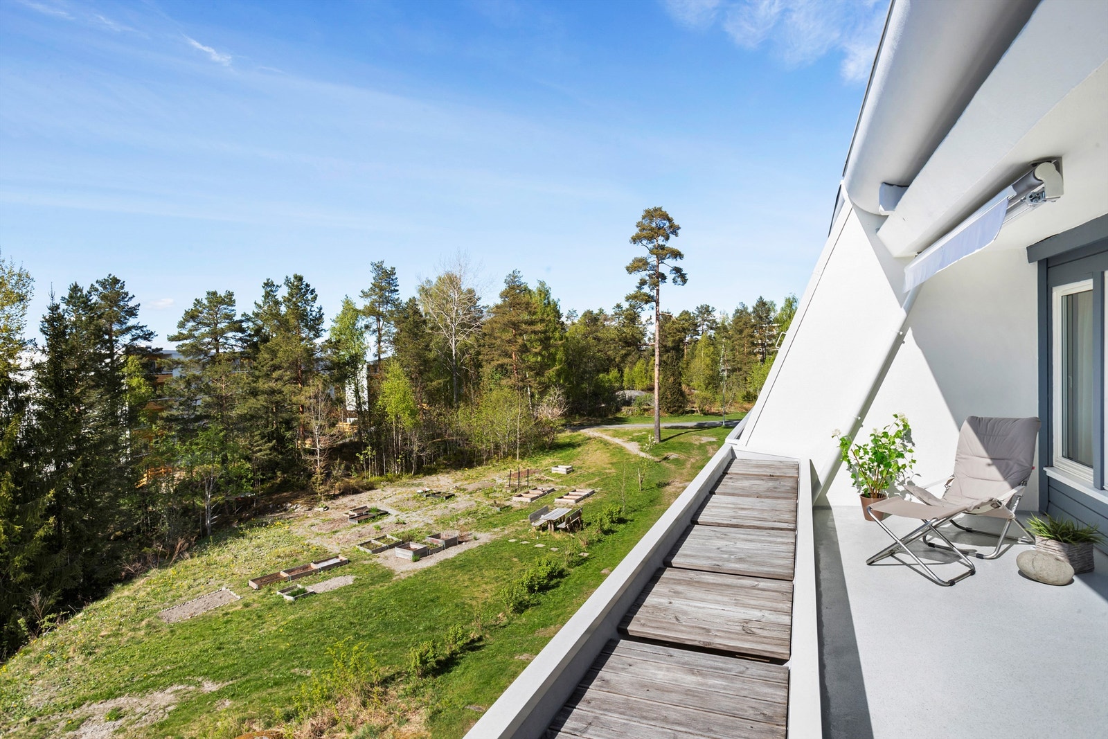 Utgang til stor terrasse med hyggelig utsyn over sameiets fellesareal med parsellhager. Galleribilde