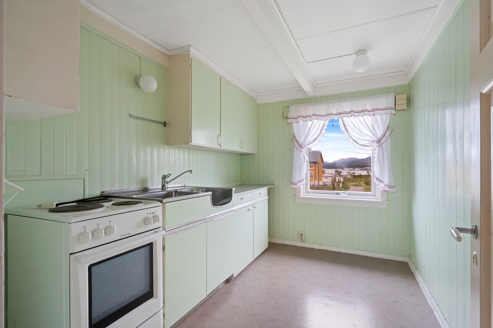 Kjøkkenet i 2. etg. er lite og koselig, med malt, plassbygd kjøkkeninnredning og vindu med utsikt mot Reksundet og bakenforliggende fjell. Galleribilde