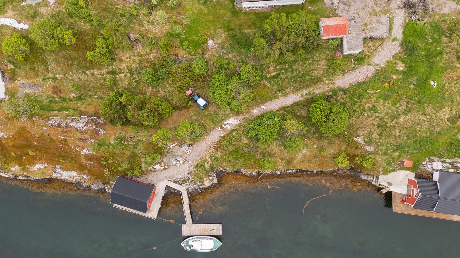Dronebilde som viser gruslagt sti mellom boligen og naustet Galleribilde