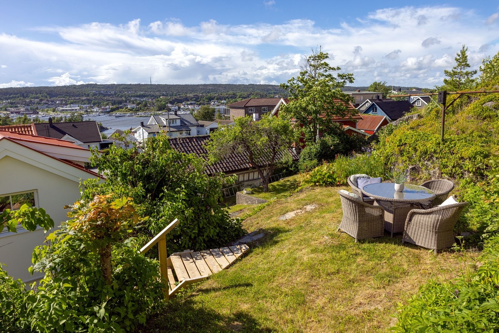 Trappen mellom syrinene tar deg opp til neste nivå - gressplen innrammet av frodige vekster. Galleribilde