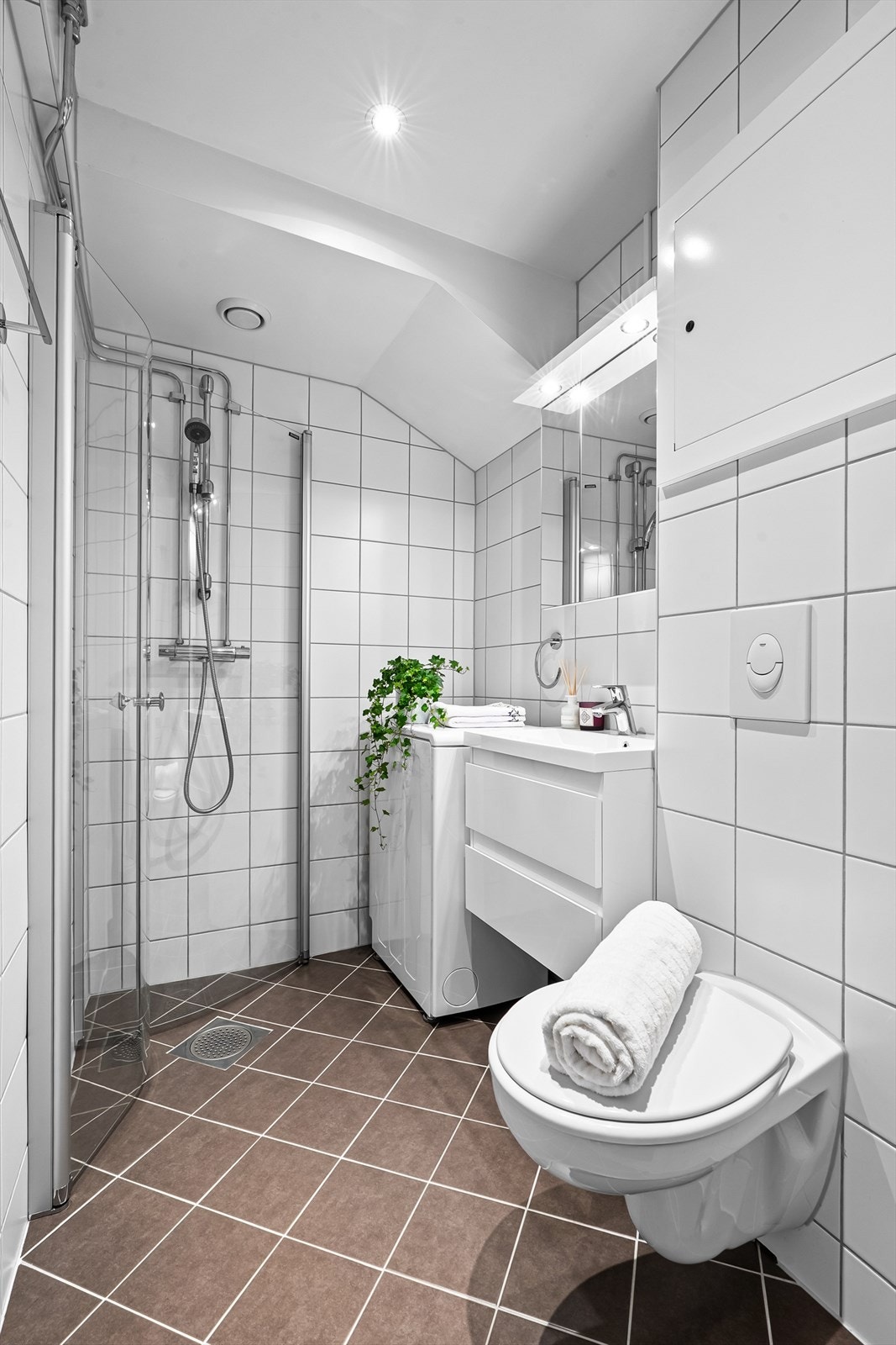 Pent, flislagt baderom med gulvvarme, downlights i himling og opplegg for vaskemaskin Galleribilde