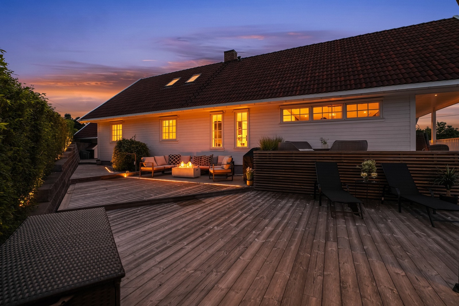 Når kvelden senker seg, forvandles terrassen til en stemningsfull oase med integrert belysning og flere soner for hygge. Galleribilde