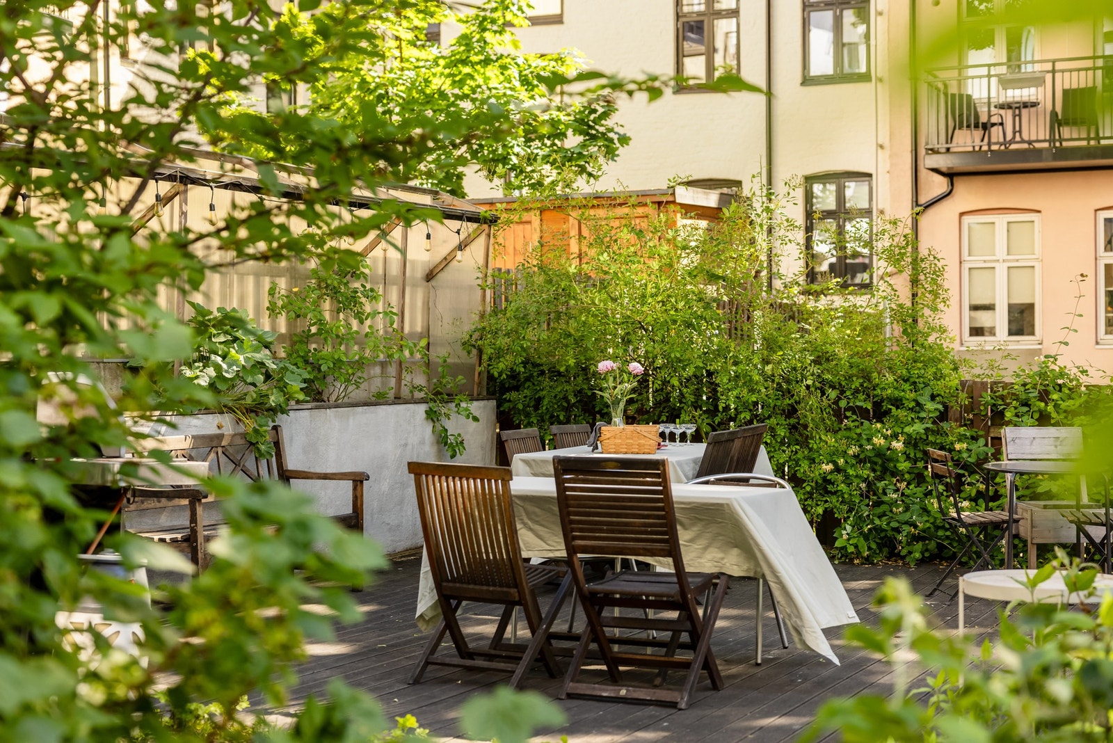 Felles tomt for borettslaget opparbeidet med blant annet asfaltert bakgård, parkeringsplasser, trær, gressplen, prydbusker og diverse beplantning. Galleribilde
