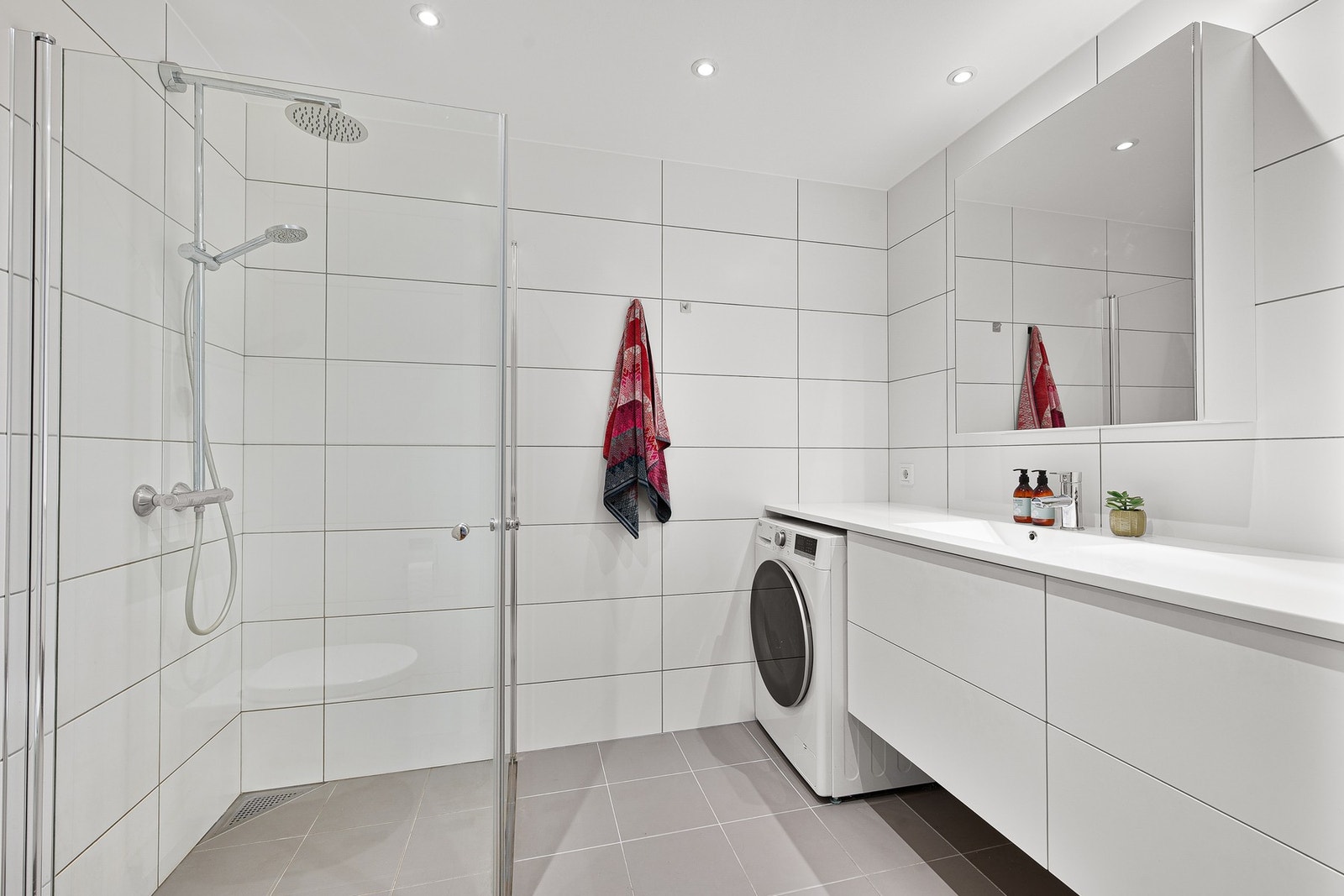 Pent og moderne flislagt bad med varme i gulv og downlights i taket Galleribilde