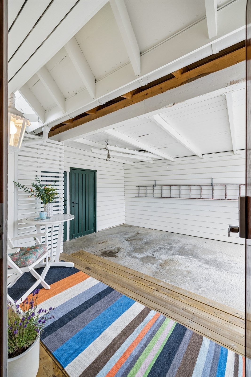 Fra inngangsdøren kan du gå tørrskodd til carporten. Her er det også boder for ekstra lagring. Galleribilde
