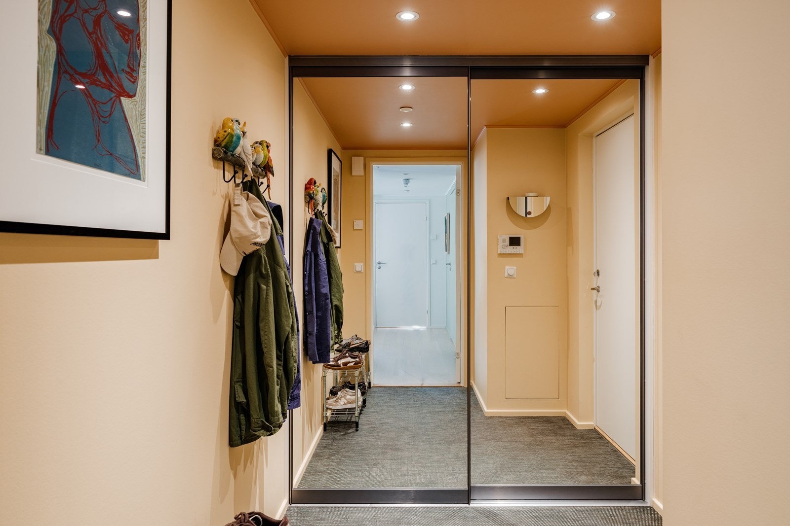 Det er god plass til oppheng av yttertøy og oppbevaring i en stor skyvedørsgarderobe Galleribilde