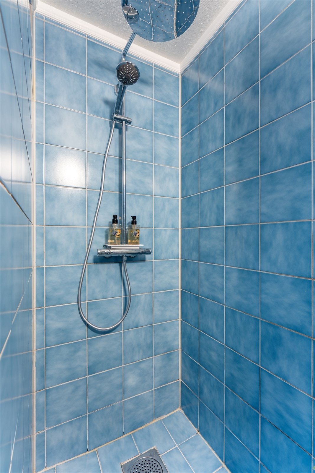 Badet i kjelleren har dusjhjørne og flislagte overflater. Galleribilde