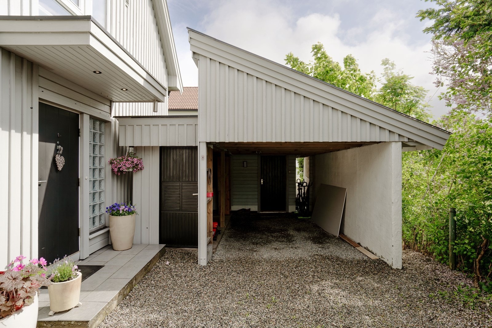 Velstelt og innbydende inngangsparti med overbygget adkomst og carport like ved - praktisk og lett tilgjengelig i hverdagen. Galleribilde