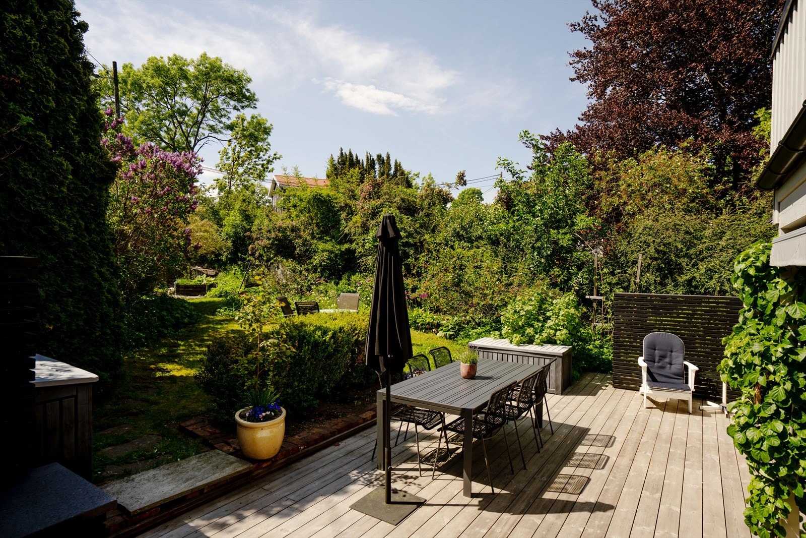 Solrik terrasse med god plass til spisegruppe og flott utsyn mot frodig hage. Galleribilde