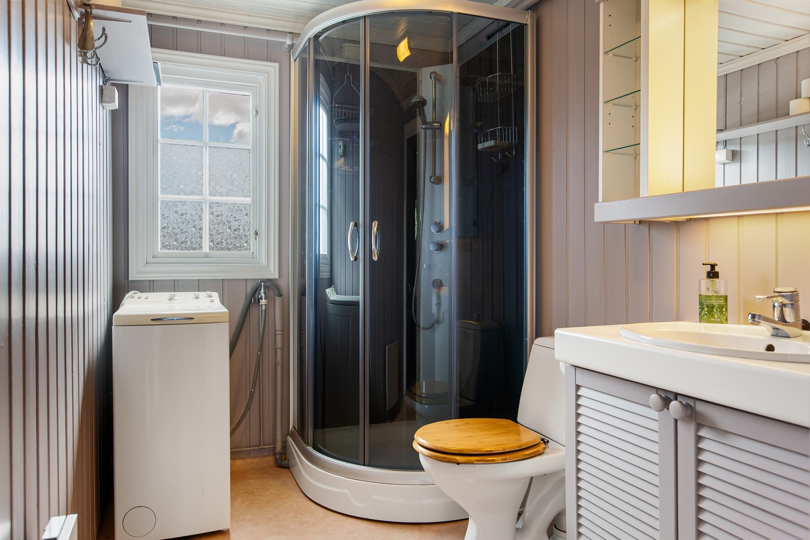 Badet har servantinnredning, toalett, dusjkabinett og opplegg til vaskemaskin. Galleribilde