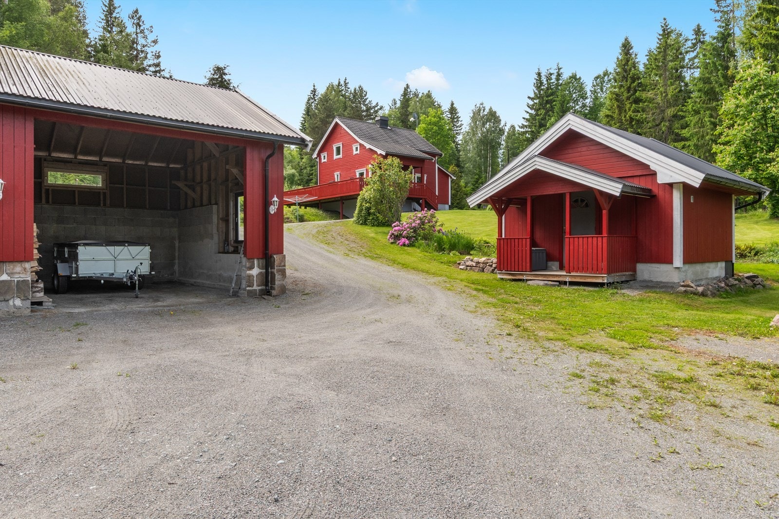 Garasjebygningen strekker seg videre med en stor, åpen garasjedel - ideell for oppstilling av tilhenger eller lagring av ved. Galleribilde