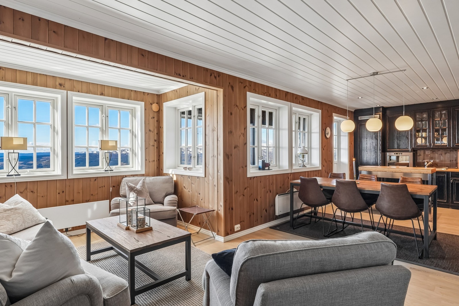Romslig oppholdsrom med store vindusflater som bringer fjellandskapet inn Galleribilde