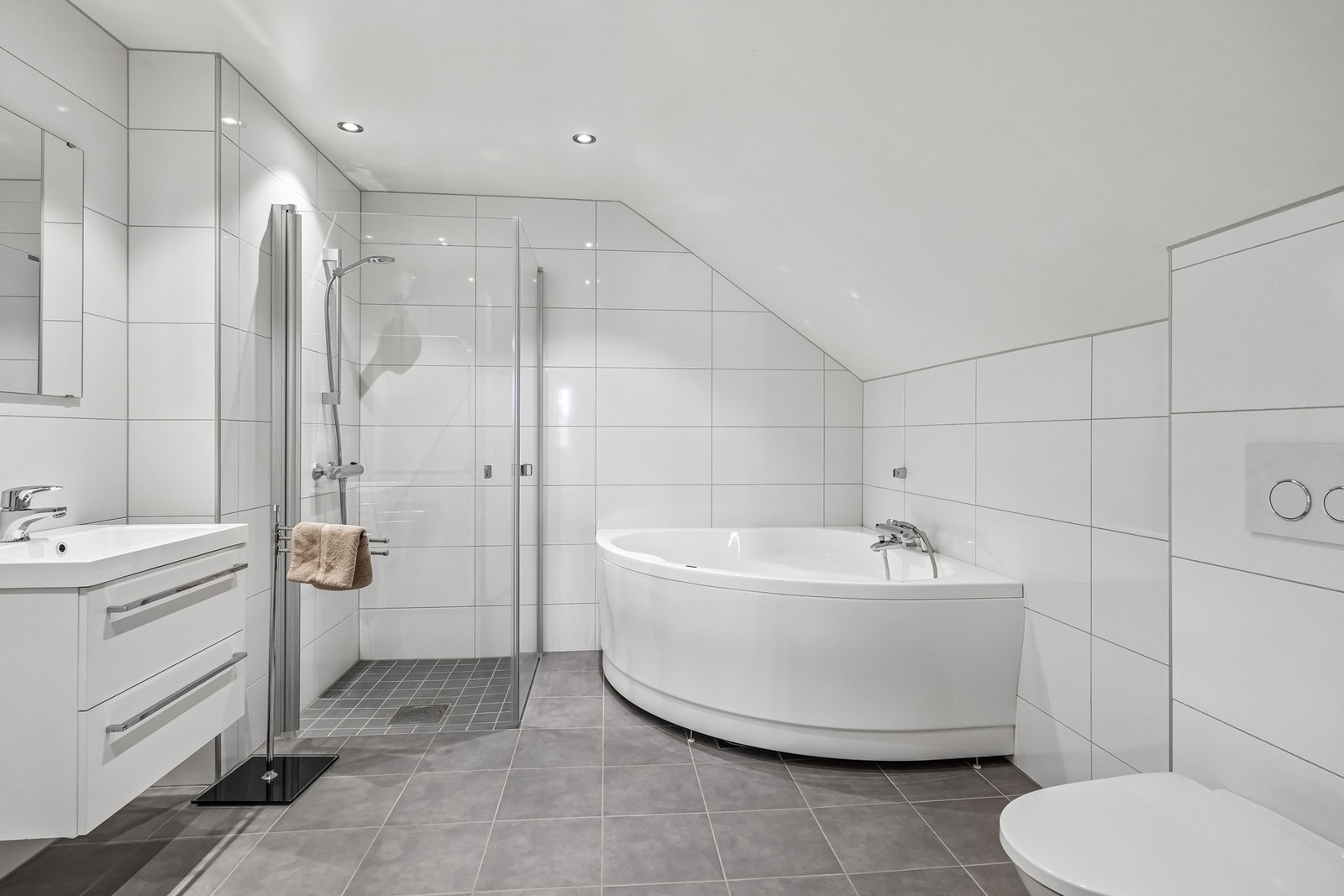 Badet i denne etasjen er også romslig og har same type flis og innredning som badet i 1.etasje.
Dette badet har i tillegg hjørnebadekar, noe som er ekstra deilig på kalde dager Galleribilde